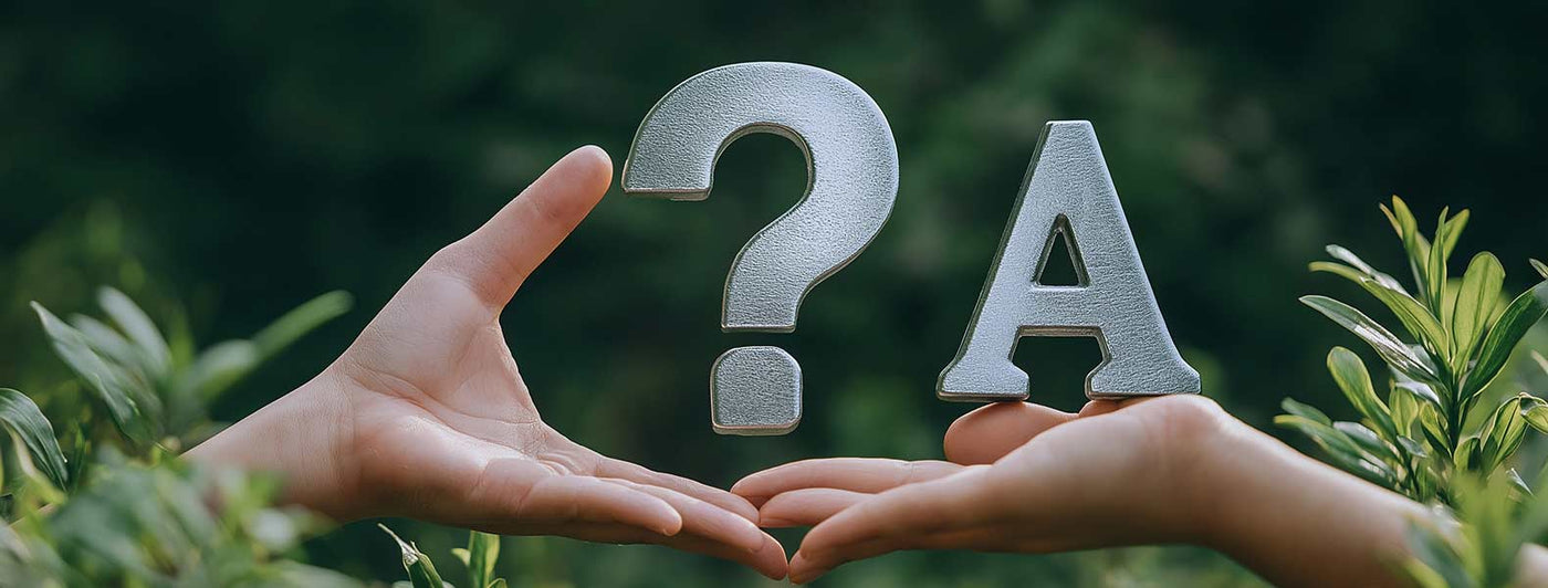 Two hands holding a metal question mark and an A with a green background.