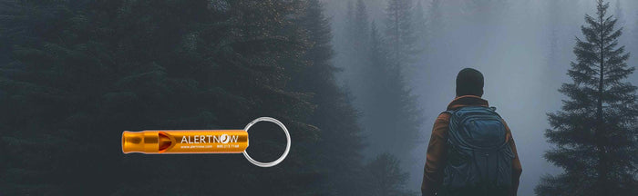 An engraved safety whistle overlaid an image of a hiker in the woods at dusk.